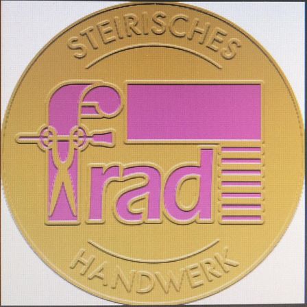 Goldener runder Logo mit dem Text 'Stirisches rad HANDWERK' in Rosa und Lila mit einer stilisierten Figur in der Mitte.