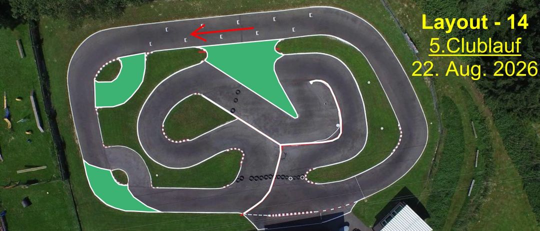 Eine Draufsicht auf eine Rennstrecke mit einem grünen Dreieck, das einen bestimmten Bereich markiert, gekennzeichnet durch einen roten Pfeil. Die Strecke ist von Gras umgeben und hat weiße Markierungen. Gebäude und Strukturen sind im Hintergrund zu sehen.