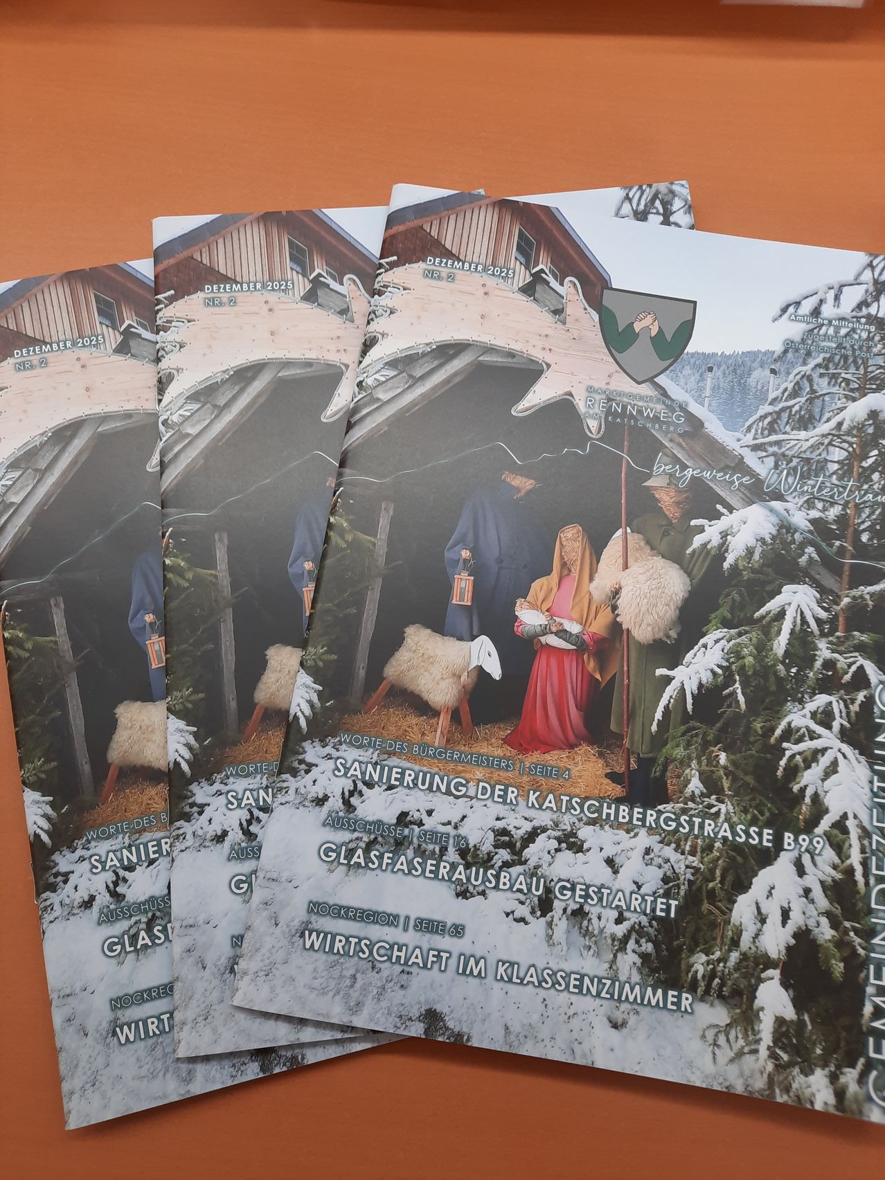 Poster, die eine Krippenszene in einer verschneiten Umgebung darstellen, mit Menschen in traditioneller Kleidung, beleuchtet von einer Laterne. Der Text lautet 'Sanieurungsmeisters' und 'Ausschusse der Klasse 8'.