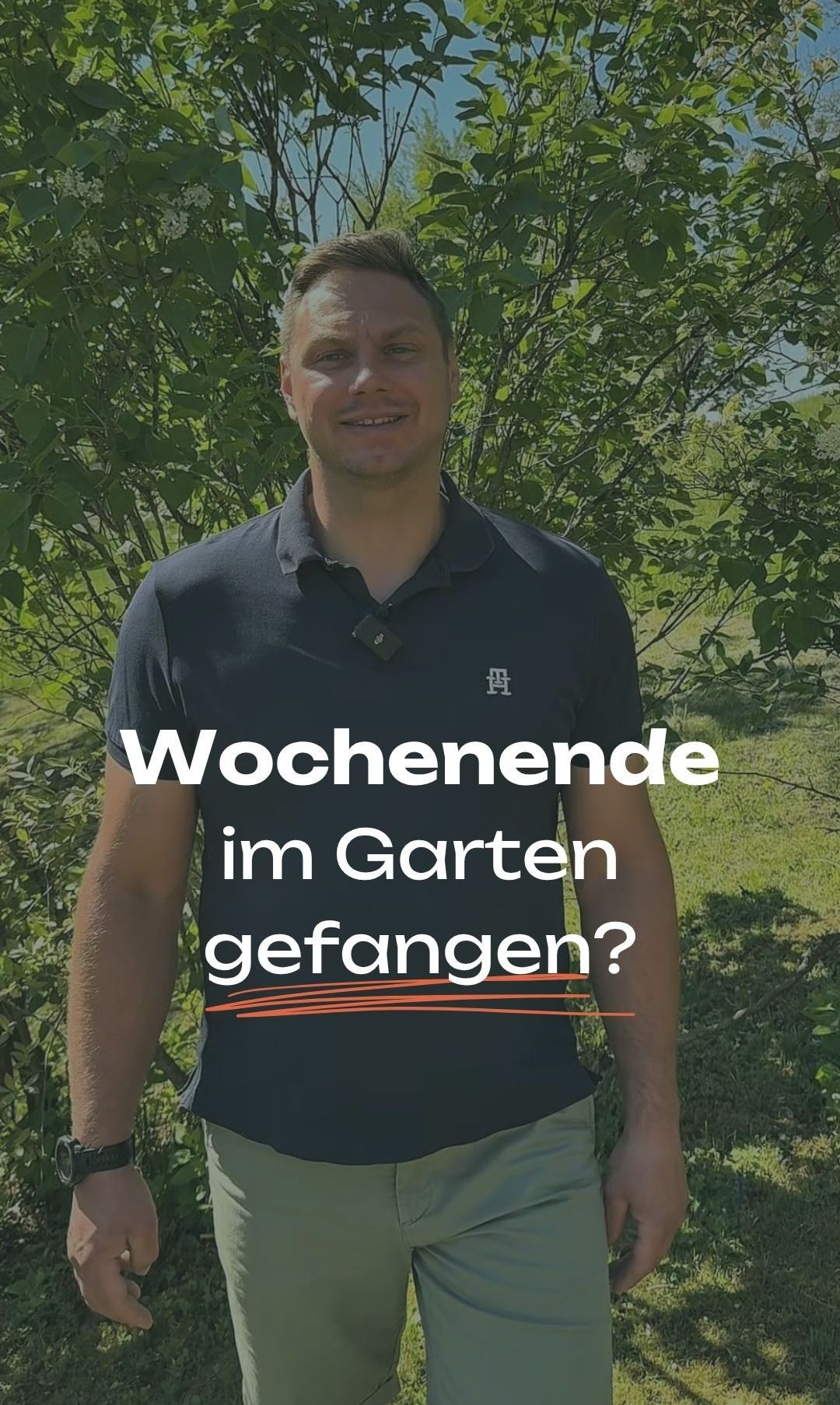Ein Mann steht in einem Garten und lächelt. Er trägt ein schwarzes Poloshirt mit weißen Buchstaben. Dahinter ein verschwommener Hintergrund aus grünen Blättern und Gras. Die Worte 'Wochenend im Garten gefangen?' sind in fetten orangefarbenen Buchstaben.