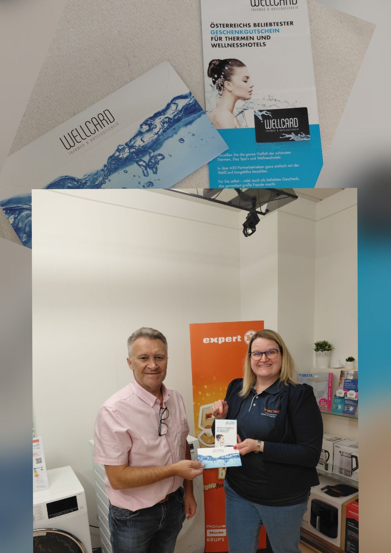 Ein Mann und eine Frau halten eine Wellcard in einem Raum mit einem orangefarbenen Banner und einem Regal mit Kartons.