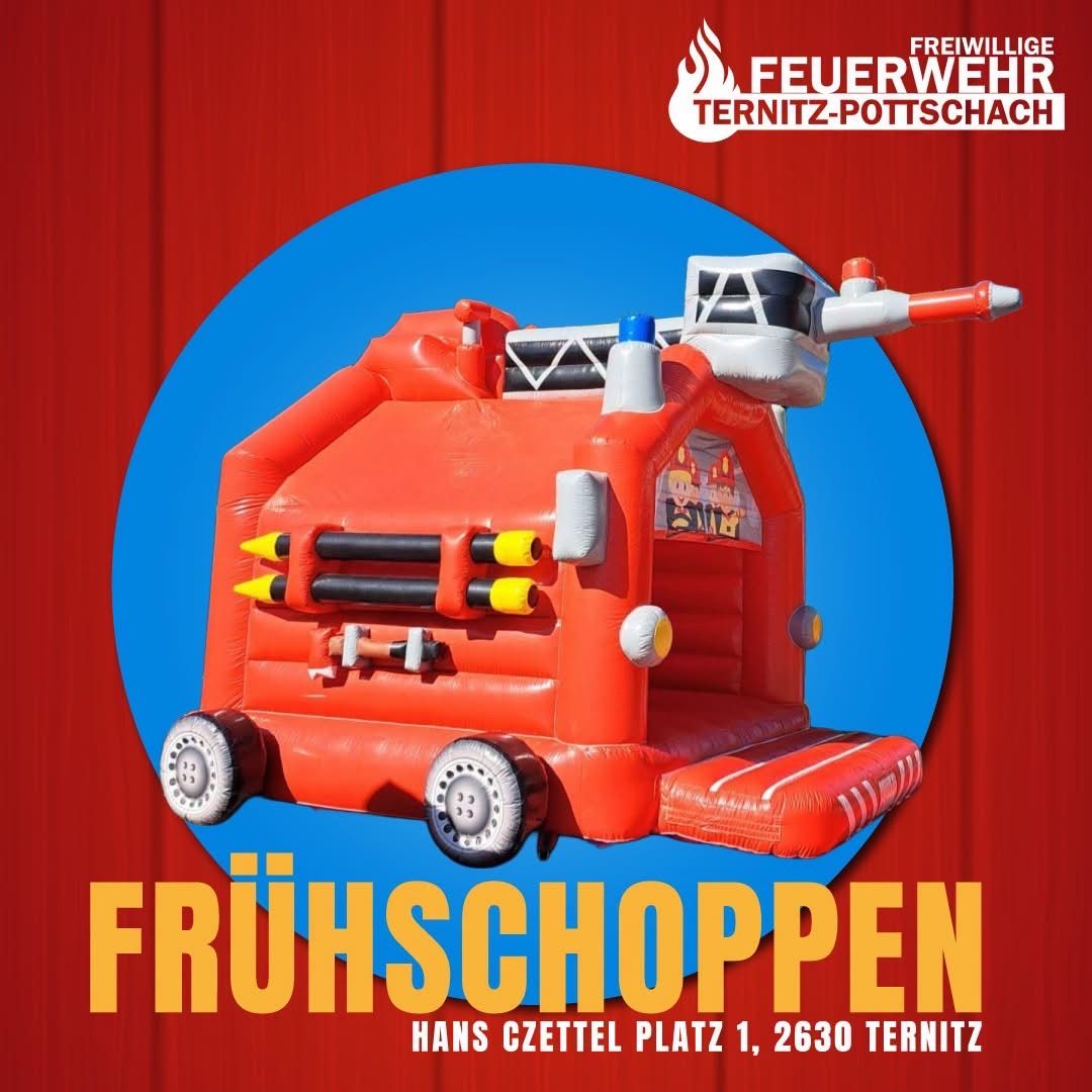 An advertisement for a fire truck bouncy house for children, featuring a vibrant red inflatable with a fireman figure and the words 'Fruhschoppnen'. The image has a blue circle background and includes the address 'Hans Czettel Platz 1, 2630 Ternitz'.