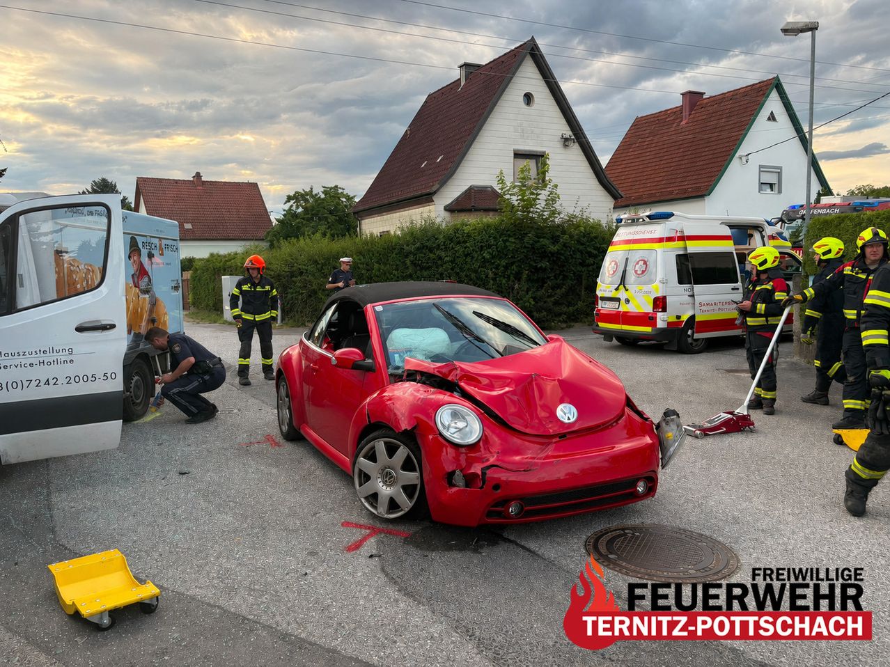 An accident involving a red car and a fire truck. A man and firefighters are present.