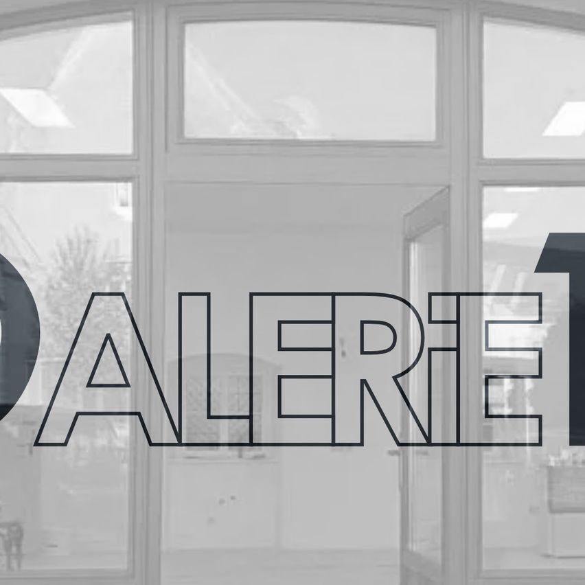 Ein Bild eines Gebäudes mit großen Fenstern und dem prominenten Wort 'ALERT'. Die Fenster reflektieren eine verschwommene Außenszene.