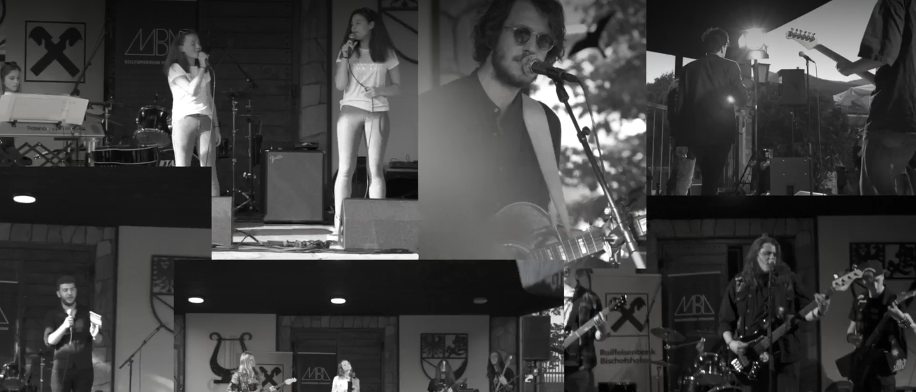 Ein Schwarz-Weiß-Foto von Musikern, die auf der Bühne auftreten. Eine Frau singt in ein Mikrofon, ein Mann spielt Gitarre und eine Band spielt im Hintergrund.