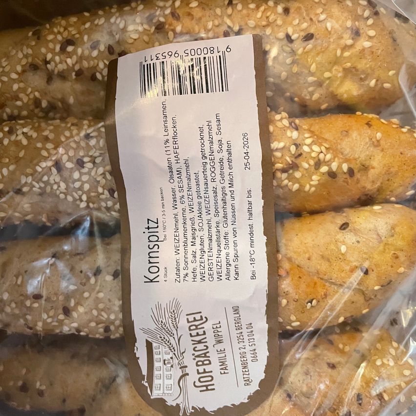 Ein Nahaufnahme von einer Tüte mit Maisgewürz-Rollen mit Sesam. Das Etikett enthält Nährwertinformationen, Zutaten und das Mindesthaltbarkeitsdatum.