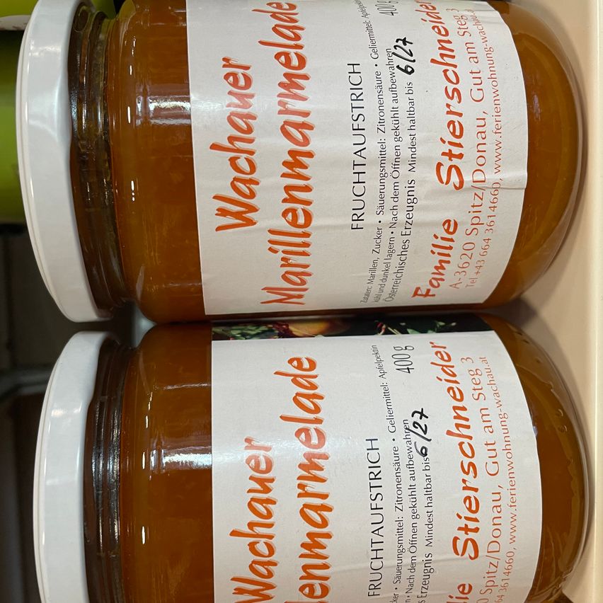 Zwei Gläser Wachauer Marillenmarmelade, eine Art Aprikosenmarmelade, übereinander gestapelt. Die Etiketten sind weiß mit orangefarbenem Text und zeigen den Markennamen und Produktinformationen.