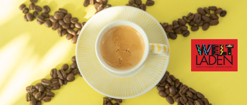 Eine Tasse Kaffee mit Untertasse, umgeben von Kaffeebohnen in einem Sonnendesign auf gelbem Hintergrund. Das Logo Welt Laden ist sichtbar.