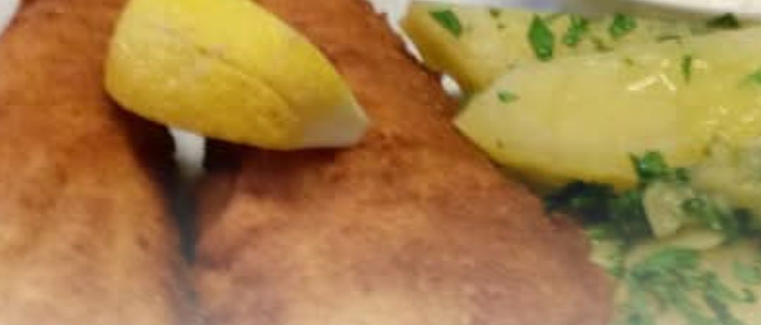 Gebratener Fisch mit Zitrone und Kartoffeln auf einem Teller mit cremiger Dip. Der Text lautet Samstag von 11:00 bis 17:00 Jobi-Fisch-Schnitzeltag AHOI.