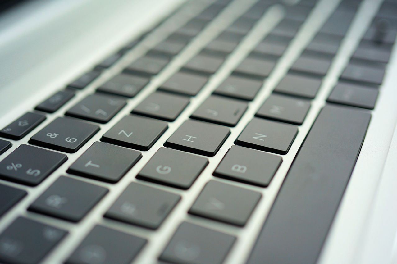 A close-up of a laptop keyboard shows a section with keys labeled 7, 8, 9, U, I, O, J, K, L, M, N, T, G, B, V, C, X, and Z.