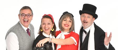 Vier Personen in Vintage-Kleidung posieren zusammen; zwei Frauen in gepunkteten Kleidern und zwei Männer, einer mit Tophut und Fliege, der andere in Weste und Krawatte.