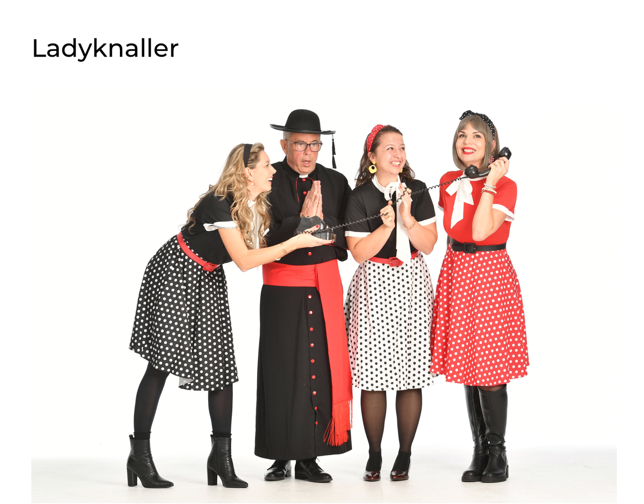 Fuenf Menschen in Retro-Kleidung posieren fuer ein Foto. Zwei Frauen an den Seiten halten Telefone, und der Mann in der Mitte traegt ein schwarzes geistliches Gewand.