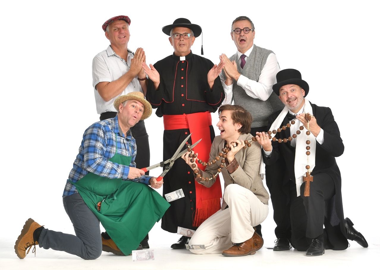 Eine Gruppe von Menschen posiert für ein Foto. Ein Mann in einem grünen Kleid hält eine Schere und eine Frau in einem weißen Kleid eine Rosenkranz. Der Mann in der Mitte ist ein Priester.