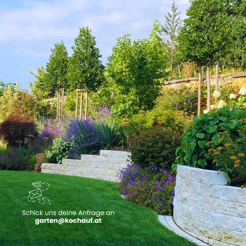 A garden with various plants, a green lawn, and a stone wall. A logo with an email address is on the lawn.