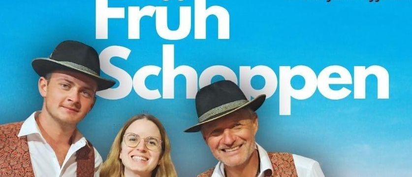 Drei Personen posieren für ein Foto bei einem Musikevent. Die Frau trägt ein traditionelles Kleid. Die Männer tragen Hüte und Westen. Der Plakattext lautet 'Früh Schoppen'. Das Event beginnt um 11:00.