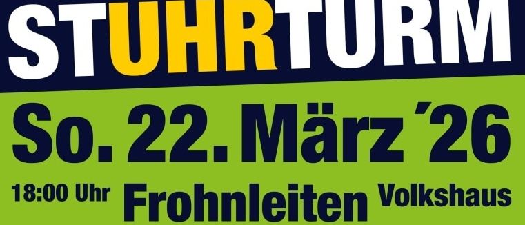 Eine Gruppe von Menschen posiert mit einer großen goldenen Uhr, die in einer Glaskugel eingeschlossen ist. Sie tragen alle schwarze T-Shirts mit weißen Turmdesigns. Das Bild hat einen blauen und grünen Hintergrund.