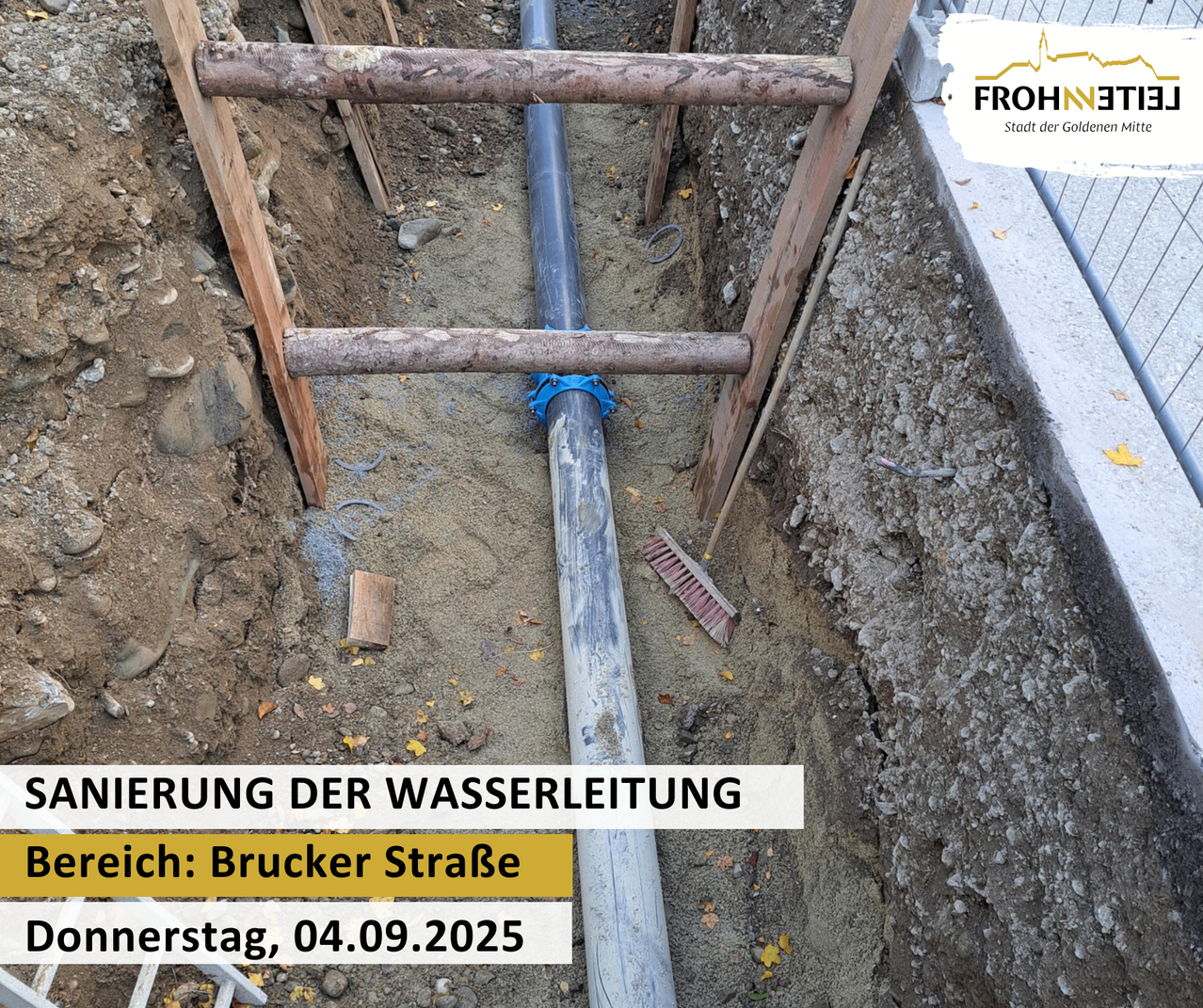 Ein Bild von einem Graben mit einer großen Rohrinstallation, Holzplanken und einer Besen, der gegen den Graben lehnt. Das Datum 04.09.2025 ist auf dem Bild geschrieben.