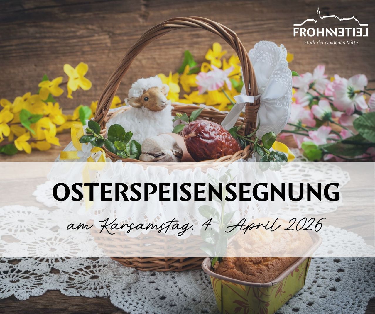 Ein Osterkorb mit Blumen, einem Plüschlamm und Ostereiern. Der Korb steht auf einem Holztisch mit der Botschaft 'Ostergeschenksegnung am Gründonnerstag, 4. April 2026'.