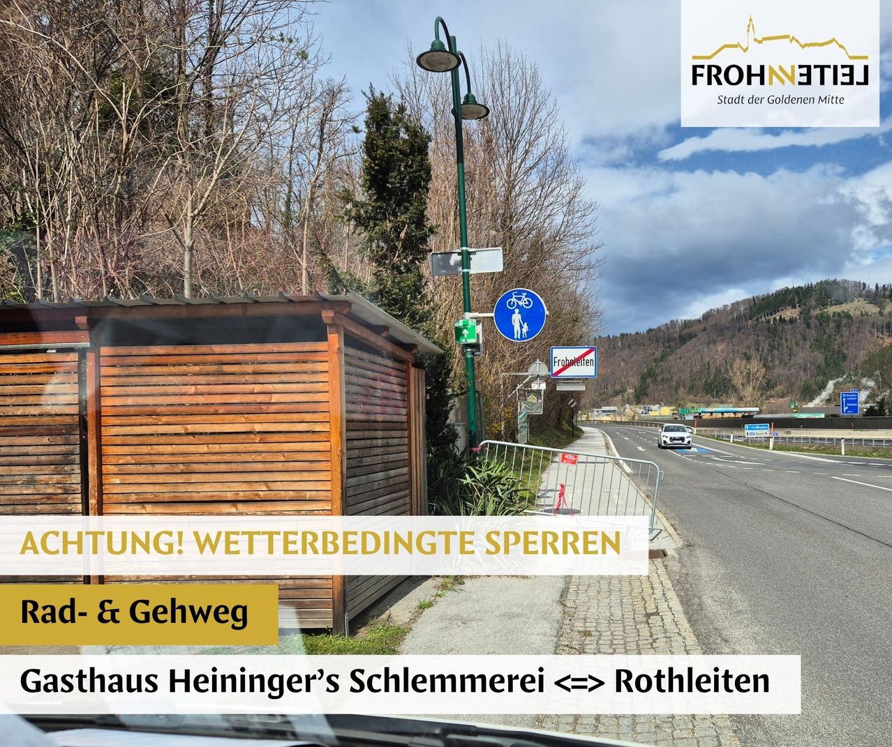 Ein Straßenschild ist am Straßenrand zu sehen, ein Auto in der Ferne. Eine hölzerne Hütte mit Dach steht am Straßenrand. Eine grüne Straßenlaterne steht am Straßenrand. Ein Berg ist in der Ferne.