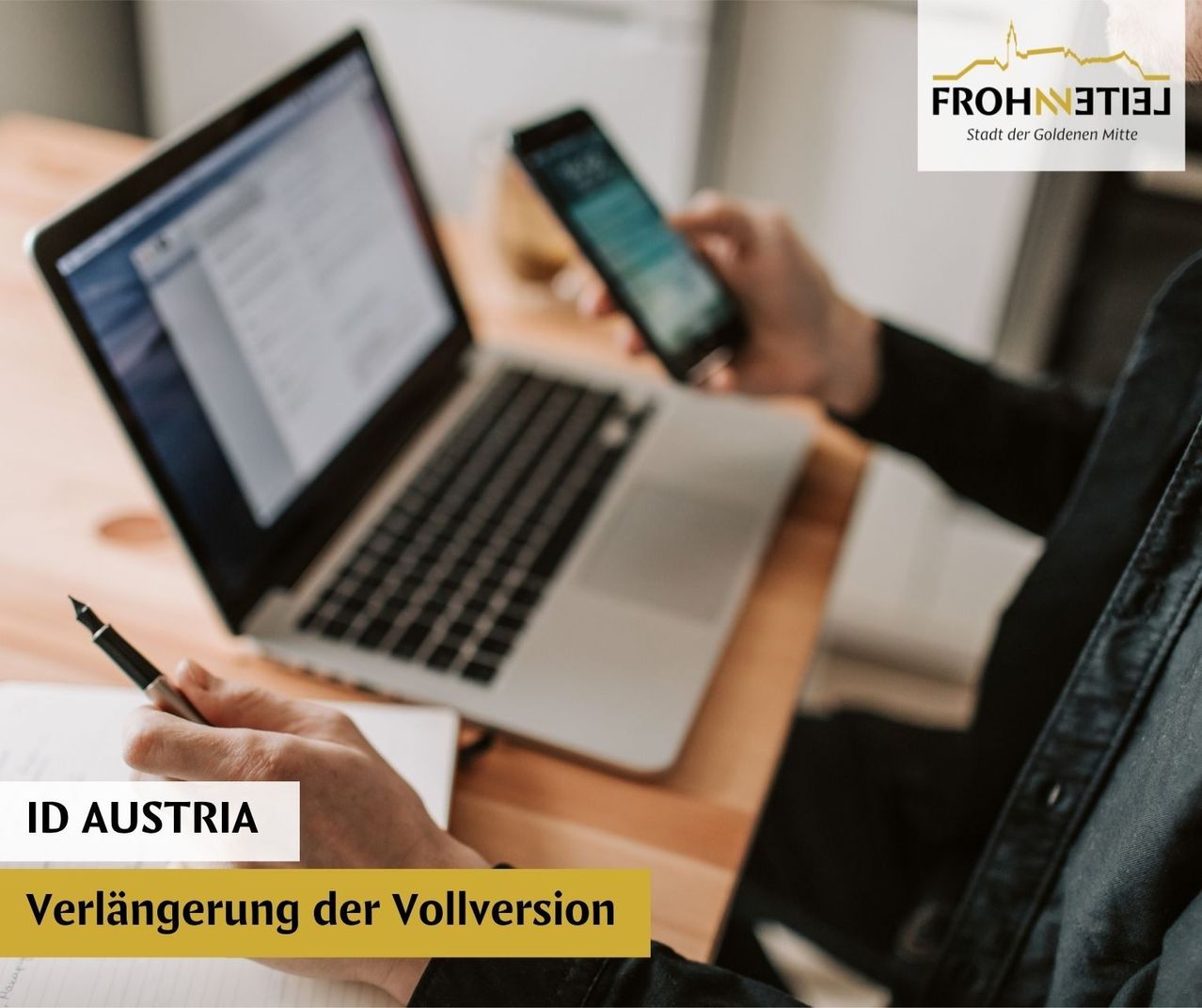 A person is sitting in front of a laptop and holding a smartphone, typing on the keyboard. There is a note with the word Austria on it. The image has a watermark in the upper right corner.