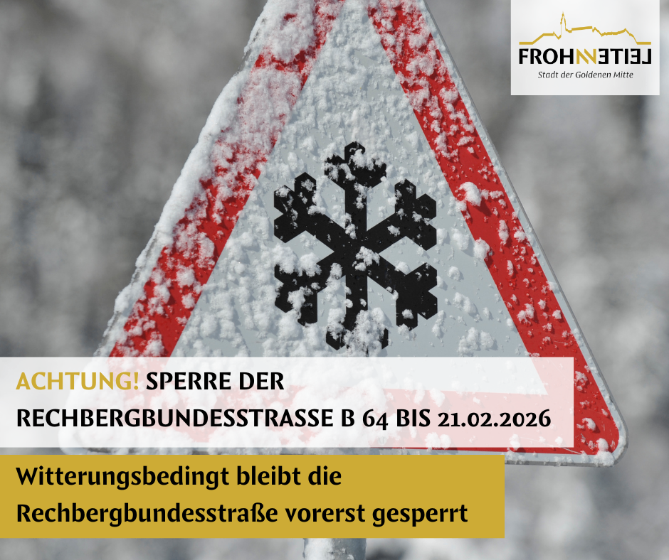 A triangular road sign covered in snow with a snowflake icon. It reads 'ATTENTION! BLOCKADE OF THE BERGBUNDESSTRASSE B 64 UNTIL 21.02.2026.' Below it, there is text stating 'Snow-related conditions leave the BERGBUNDESSTRASSE temporarily blocked.'