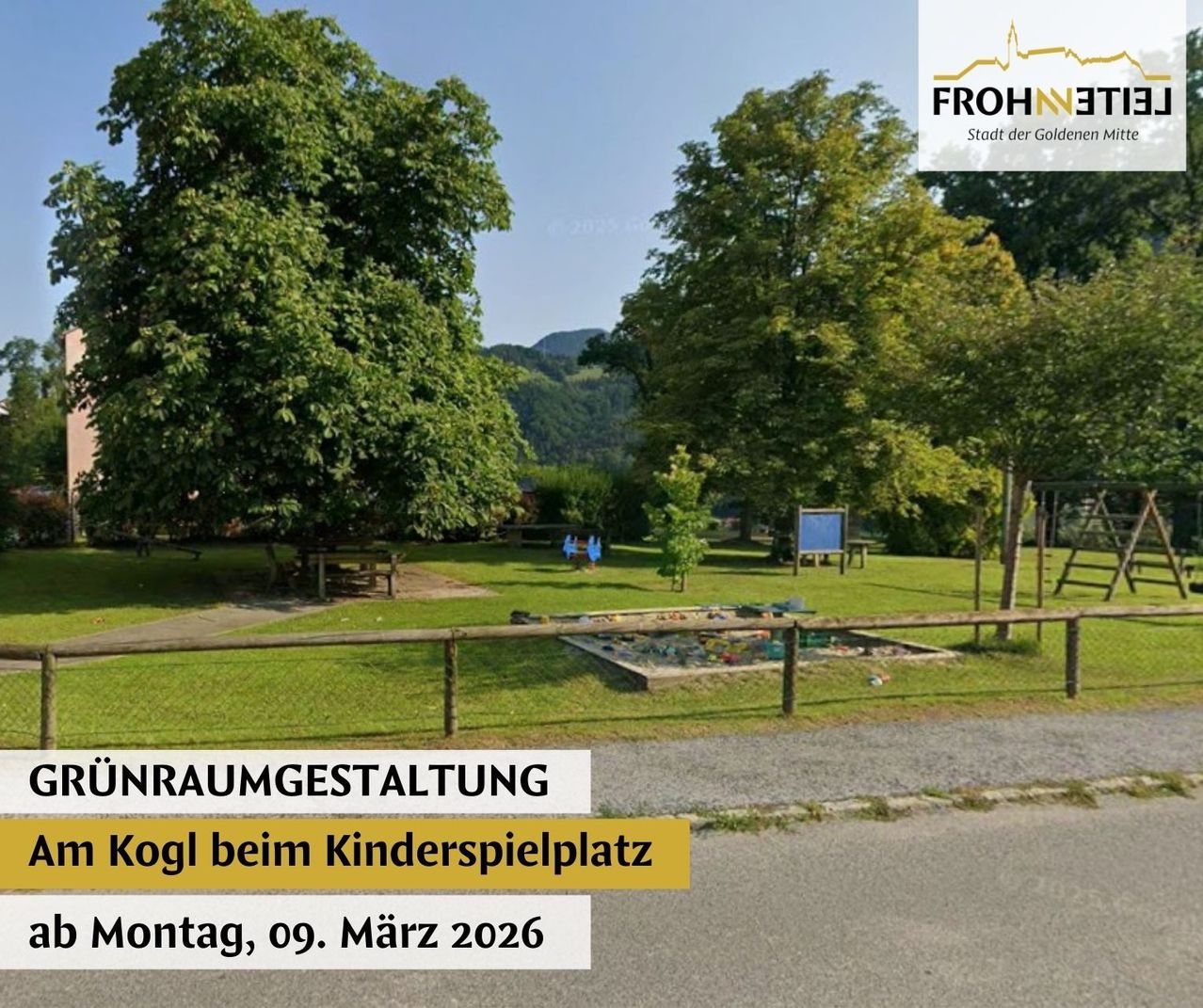 Outdoor event at the children's playground, March 9, 2026. The area is surrounded by a wooden fence. Trees and grass surround the playground, with a blue board in the middle. In the distance, there are mountains.