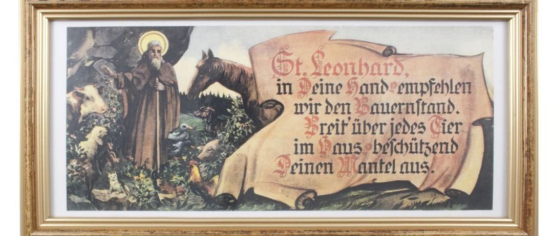 Ein gerahmtes Gemälde zeigt den Heiligen Leonhard, einen alten Mann mit Bart und Stab, der mit einem Pferd und einer Kuh steht. Das Gemälde hat ein Banner mit deutschem Text.
