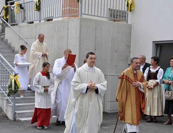 Eine Gruppe von Priestern und Kirchenbesuchern versammelt sich vor einer Kirche, möglicherweise für eine religiöse Zeremonie.