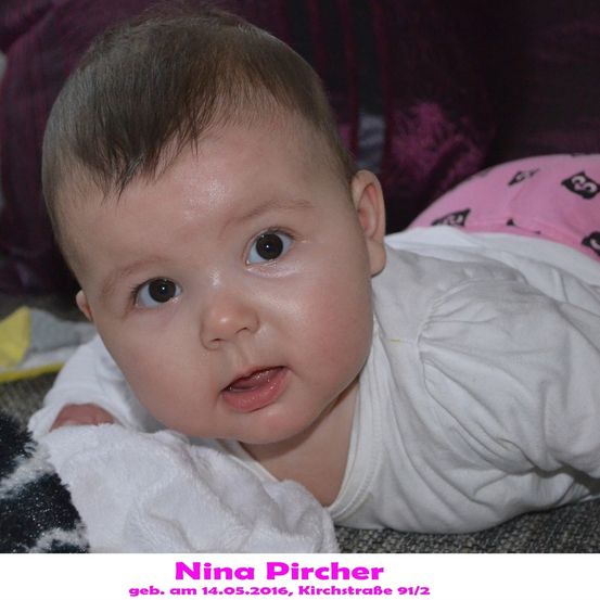 Ein Babymädchen namens Nina Pircher, geboren am 14. Mai 2016, liegt auf einem Teppichboden und trägt ein weißes Shirt und rosa Hose.