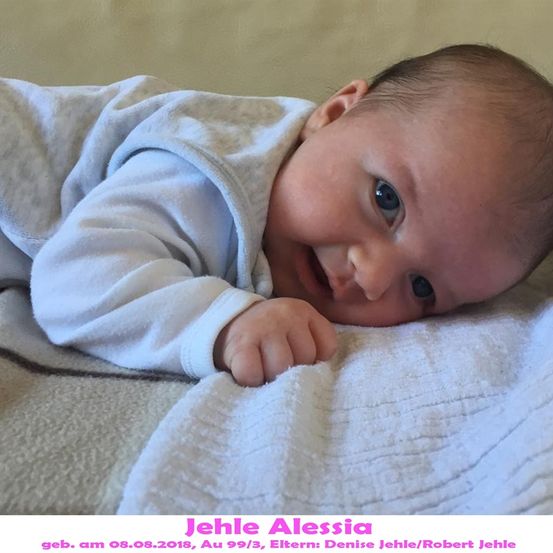 Ein lächelndes Babymädchen, Alessia Jehle, geboren am 08.08.2018, liegt auf einer weißen Decke mit den Namen der Eltern unten.