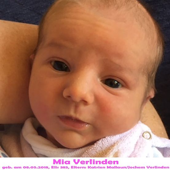 Ein Nahaufnahme eines Babymädchens namens Mia Verlinden, geboren am 8. Mai 2018, trägt ein weißes Lätzchen und schaut direkt in die Kamera.