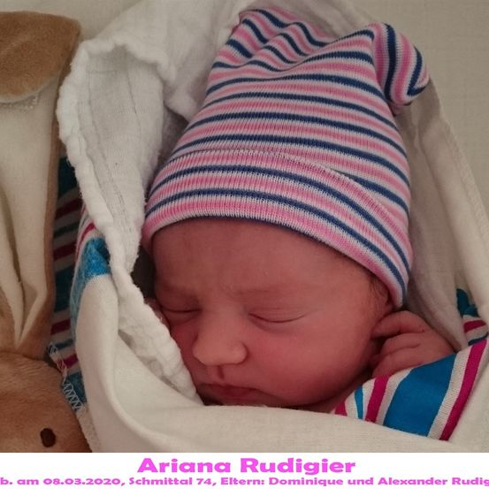 Ein schlafendes Neugeborenes, Baby-Mädchen Ariana Rudigier, geboren am 8. März 2020, in eine weiße Decke gewickelt mit einer pink-blau gestreiften Mütze.
