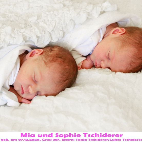 Zwei Neugeborene, Mia und Sophie, schlafen friedlich auf einer weißen Decke. Sie sind in weiße Tücher gewickelt und haben die Augen geschlossen. Das Bild ist vom 07.12.2020.