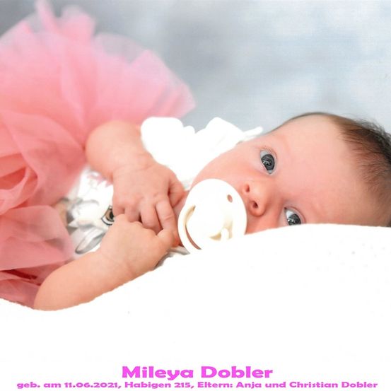 Ein Babymädchen namens Mileya Dobler, geboren am 11.06.2021 in Habigen 215, mit Eltern Anja und Christian Dobler, liegt auf einer weißen Decke und hält einen Schnuller.
