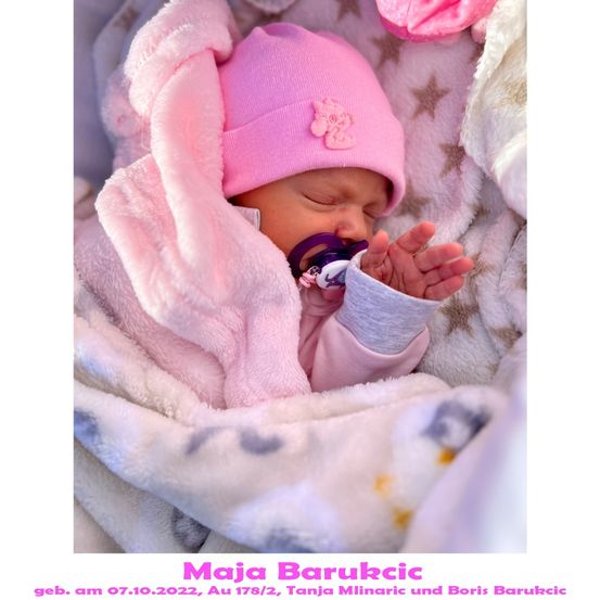Ein neugeborenes Babymädchen, Maja Barukcic, geboren am 7. Oktober 2022, schläft friedlich in einer rosa Decke und Mütze und hält einen Schnuller.