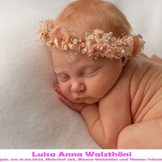 Ein neugeborenes Mädchen, Luisa Anna, schläft friedlich mit einer Blumenkrone auf dem Kopf, geboren am 15. März 2023, von Bianca und Thomas.