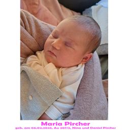 Ein neugeborenes Babymädchen, Maria Pircher, geboren am 6. Februar 2023, schläft friedlich auf der Schulter ihrer Mutter. Sie ist in eine gestrickte Decke gewickelt.