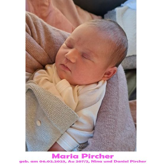 Ein neugeborenes Babymädchen, Maria Pircher, geboren am 6. Februar 2023, schläft friedlich auf der Schulter ihrer Mutter. Sie ist in eine gestrickte Decke gewickelt.