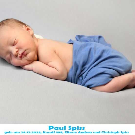 Ein Neugeborenes namens Paul Spiss, geboren am 29.12.2023 in Kuratli 398, schläft friedlich auf einer grauen Oberfläche und trägt einen blauen Stoff.