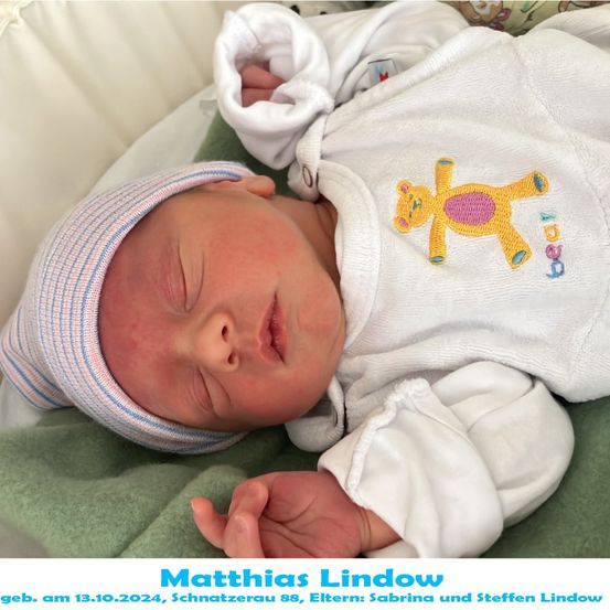 Neugeborenes Baby Matthias Lindow, geboren am 13.10.2024, schläft friedlich auf einer grünen Decke mit einer gestreiften Mütze und einem Teddybären, der auf seinem weißen Outfit gestickt ist.