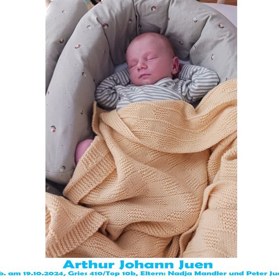 Ein Neugeborenes namens Arthur Johann Juen, geboren am 19. Oktober 2024, schläft friedlich in einem Kinderbett mit einer gestrickten Decke.
