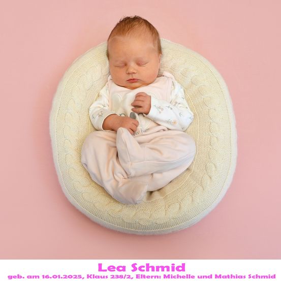 Ein Babymädchen schläft friedlich auf einem gestrickten runden Kissen und trägt ein rosa Outfit mit Blumenmuster. Der Hintergrund ist rosa.