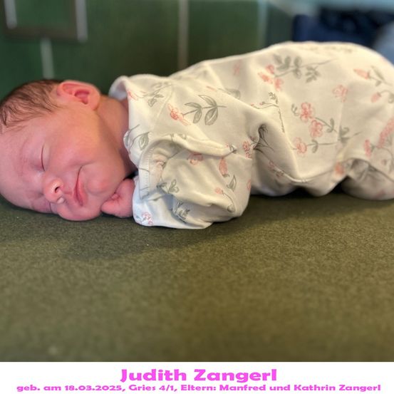 Ein neugeborenes Babymädchen schläft friedlich auf einer grünen Oberfläche und trägt einen Overall mit Blumenmuster. Das Bild enthält einen Wasserzeichen mit dem Namen des Fotografen und den Geburtsdaten des Babys.
