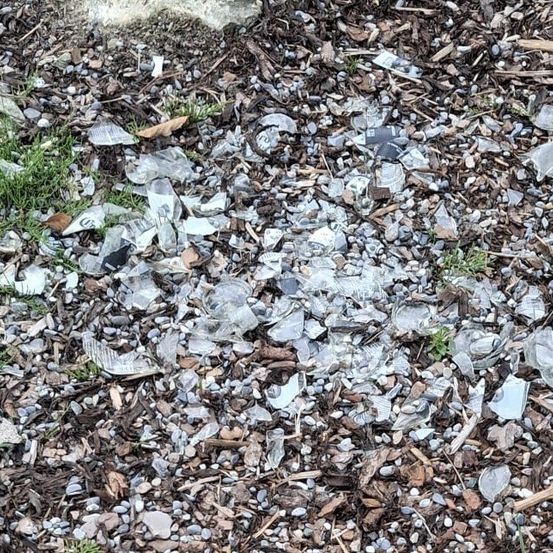 Ein Boden, der mit kleinen Stücken von zerbrochenem Glas und anderem Abfall bedeckt ist.