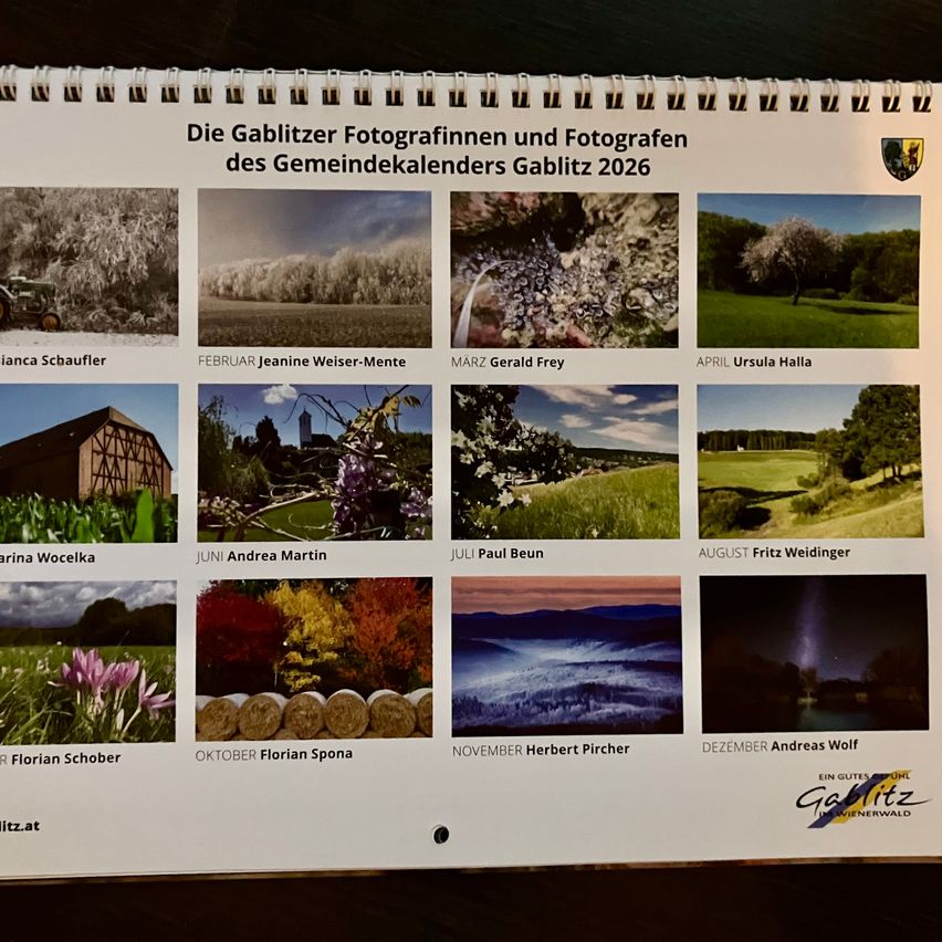 Ein Gemeindekalender aus dem Jahr 2026 mit Fotografien von Gablitzer Fotografen, der Bilder von Landschaften, Blumen und Architektur verschiedener Fotografen zeigt, mit Monaten in deutscher Sprache beschriftet.