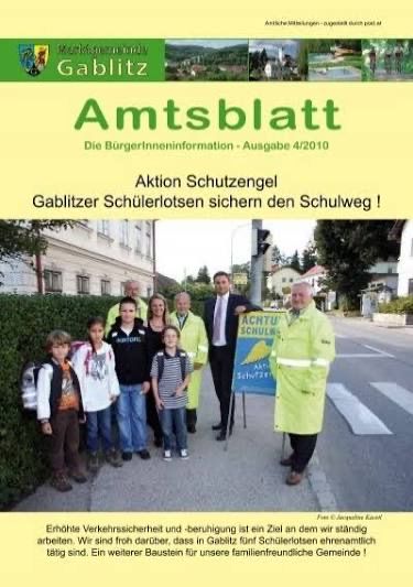 Official municipal bulletin with a focus on traffic safety and children's protection. The cover features a group of people, including students, standing near a traffic sign. The text emphasizes the importance of safety for children on the school path.