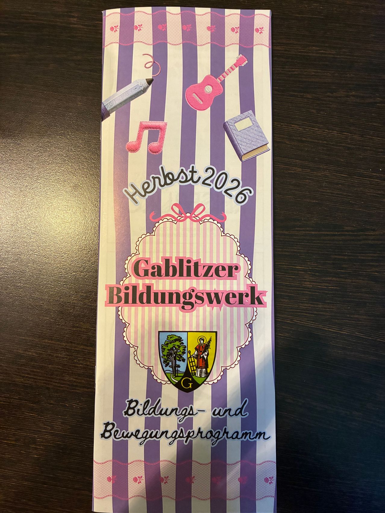 A colorful poster with a pencil, a book, and a guitar on a striped background. It says Herbst 2026 and Gabiitzer Bildungswerk.