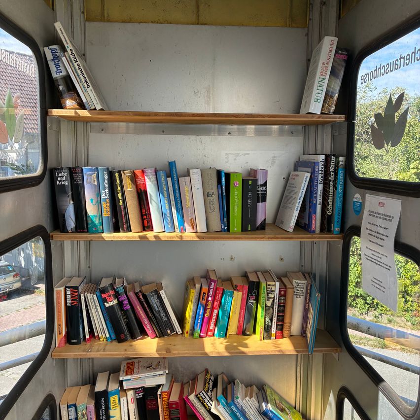 Bücherregal in einer Telefonzelle in Österreich mit Büchern auf drei Ebenen