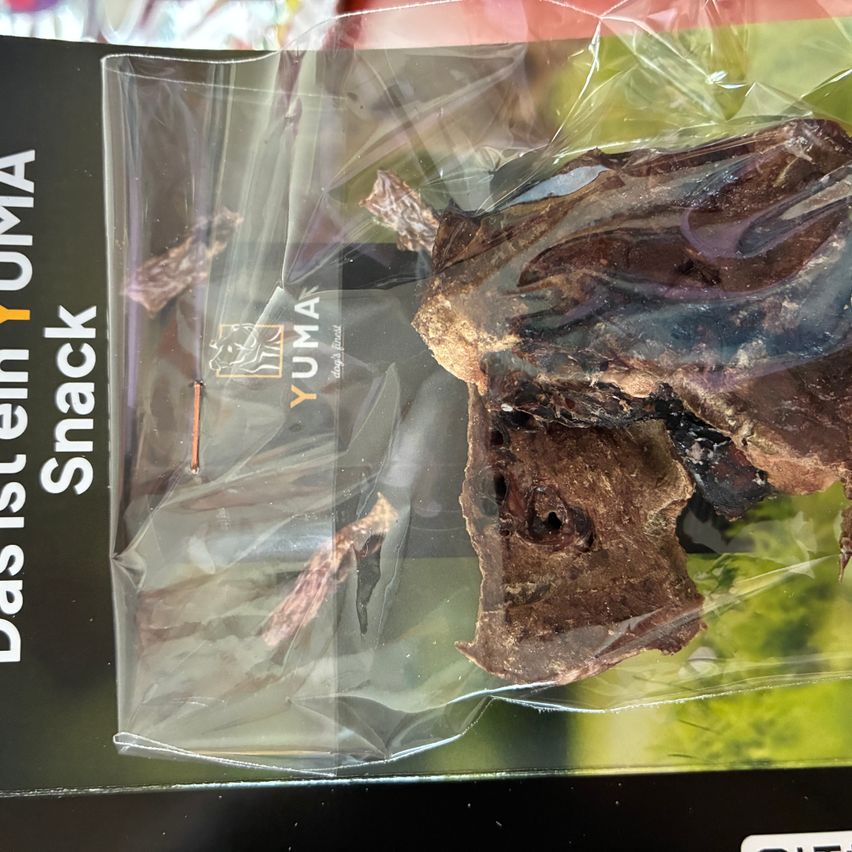 A package of YUMA Das Stein Snack, containing a dried, brownish meaty item in a clear plastic bag.