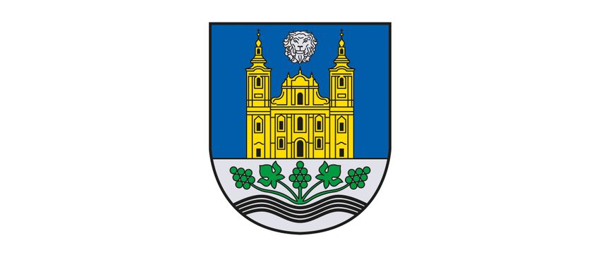 Ein blauer Schild mit einer gelben Kirche in der Mitte, zwei Türmen und einem weißen Löwen obenauf. Unter der Kirche befindet sich eine grüne, wellenförmige Linie mit Trauben.